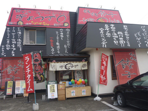 「もちもち餃子」。そして店舗の屋根には、なにやら詩的な文字がびっしり。 
